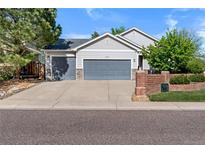 Charming home featuring a three-car garage and beautiful landscaping, creating an inviting curb appeal at 4290 S Deframe St, Morrison, CO 80465