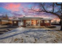 Brick ranch house with snow-covered lawn and attached garage at 2994 S Winona Ct, Denver, CO 80236