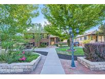 Charming brick home featuring a manicured front yard, mature trees and inviting curb appeal at 3175 S Gilpin St, Englewood, CO 80113