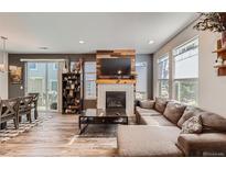 Bright living room boasts a fireplace, wood floors, and a cozy seating area, perfect for relaxation and entertaining guests at 3075 Distant Rock Ave, Castle Rock, CO 80109