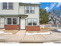 Charming townhome featuring a well-maintained exterior and neatly landscaped front yard at 6052 Jay St, Arvada, CO 80003