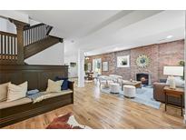 Bright, open living space featuring a brick fireplace, hardwood floors, and a cozy seating area at 734 N Downing St, Denver, CO 80218