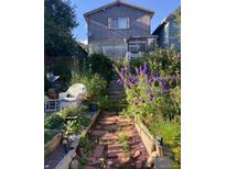 Idyllic backyard garden featuring brick pathways and lush flower beds, leading up to the home at 810 Miner St, Idaho Springs, CO 80452