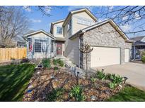 Beautiful two-story home showcasing the front yard with decorative rocks and landscaping and a two car garage at 12705 Home Farm Dr, Westminster, CO 80234