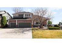 Charming home boasts a brick facade, attached two-car garage, and a well-maintained lawn at 12 Twin Flower, Littleton, CO 80127