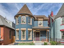 Charming two-story blue home with a turret and a cozy front porch perfect for relaxing at 209 S Lincoln St, Denver, CO 80209