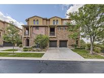 Beautiful townhome with a stone facade, two-car garage, balcony and manicured landscaping at 3491 Cascina Pl # D, Highlands Ranch, CO 80126