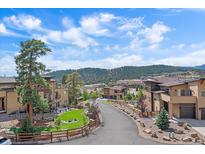 Beautiful view of community street featuring well-maintained homes, landscaping, and mountain views in the background at 756 Dreamcatcher Ln, Evergreen, CO 80439