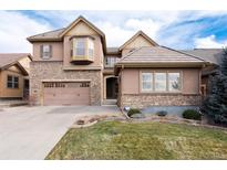 Charming two-story home with a stone and stucco facade, a well-manicured lawn, and an attached two-car garage at 10618 Soulmark Way, Highlands Ranch, CO 80126