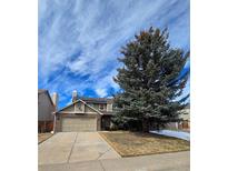 Charming two-story home with a well-maintained lawn, a large tree and a two-car garage at 5221 E Prescott Ave, Castle Rock, CO 80104