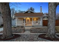 Charming home with a cozy front porch, well-manicured landscaping, and beautiful stone accents at 2033 E 21St Ave, Denver, CO 80205