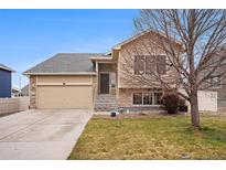 Charming two-story home with a well-manicured lawn, two car garage, and a stone and siding exterior at 5210 Roadrunner Ave, Firestone, CO 80504