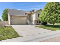 Charming two-story home with a well-manicured lawn and a two car garage on a sunny day at 5210 Roadrunner Ave, Firestone, CO 80504