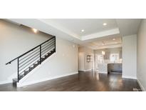 Bright living room with hardwood floors, a modern staircase, and an open concept leading to the kitchen at 2858 W Parkside Pl, Denver, CO 80221