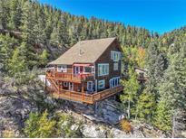 Stunning three-story mountain home with multiple wooden decks on a picturesque, wooded lot with beautiful views at 31324 Kings Vly, Conifer, CO 80433