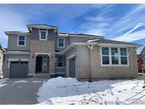 Two-story house with stone accents and a three-car garage at 635 Twilight St, Erie, CO 80516