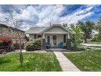 Charming home featuring a quaint front porch and well-maintained lawn under a partly cloudy sky at 3201 S Pearl St, Englewood, CO 80113