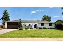 Charming ranch-style home with a well-manicured lawn, eye-catching curb appeal, and a lovely blue front door at 4192 S Vrain St, Denver, CO 80236