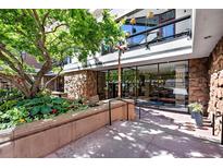 Stone and concrete building entrance with large glass windows and landscaping at 1020 15Th St # 210, Denver, CO 80202