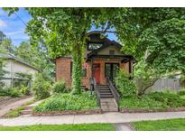 Charming brick home with mature trees, inviting porch, and landscaped front yard offers curb appeal at 1010 Euclid Ave, Boulder, CO 80302