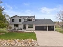 Stunning two-story home with a three-car garage, inviting front porch, and well-maintained landscaping at 7575 E Windlawn Way, Parker, CO 80134