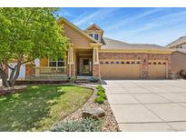Charming two-story home with manicured lawn, brick accents, and spacious three car garage at 23426 Briar Leaf Ave, Parker, CO 80138