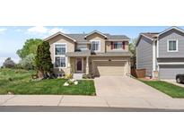 Charming two-story home featuring a well-manicured front lawn and attached two-car garage at 408 Sylvestor Trl, Highlands Ranch, CO 80129