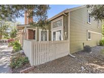 Charming home with an attractive exterior, complemented by a white picket fence and lovely landscaping at 14076 E Radcliff Cir, Aurora, CO 80015