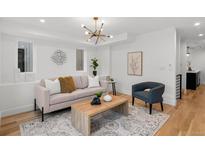 Bright living room featuring modern light fixture, hardwood floors, and stylish contemporary furnishings at 2451 Lawrence St # 2, Denver, CO 80205