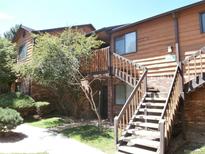 Apartment complex with brick and wood facade, stairs to upper units, and green landscaping at 2215 S Buckley Rd # 201, Aurora, CO 80013