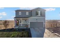Charming two-story home with an attached two-car garage and covered front porch at 4548 River Highlands Loop, Elizabeth, CO 80107