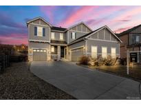 Charming two-story home boasts manicured landscaping, a long driveway, and inviting curb appeal at 21028 E Saratoga Ave, Aurora, CO 80015