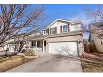 Charming two-story home featuring a brick facade and attached two-car garage in a suburban setting at 1832 S Tamarac St, Denver, CO 80231