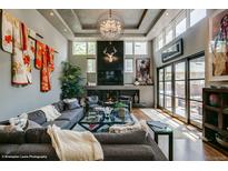 Bright living room with a dark fireplace, a large sectional sofa, and high ceilings with unique chandelier lighting at 460 Garfield St, Denver, CO 80206