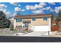 Charming home featuring a manicured front yard, two-car garage, and inviting entrance at 13225 W Jewell Cir, Lakewood, CO 80228