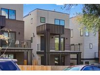 Modern three-story townhome with dark brick exterior and balcony at 1256 Newton St # 1, Denver, CO 80204