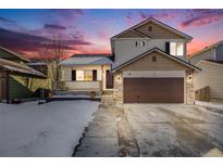 Two-story house with attached garage and snowy front yard at 11840 E 117Th Ave, Commerce City, CO 80640