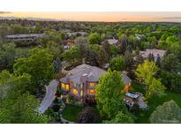Stunning home featuring a lush landscaped yard, driveway, and outdoor spa at 7050 S Polo Ridge Dr, Littleton, CO 80128