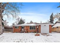 Charming brick home featuring an attached garage and front yard covered in a blanket of snow at 205 Coral Way, Broomfield, CO 80020