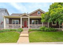 Charming home featuring a covered porch with a red front door and well-maintained landscaping at 5137 Mt Arapaho Cir, Frederick, CO 80504