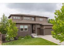 Beautiful two-story home featuring a well-manicured lawn, brick accents, and a two-car garage at 11880 W 38Th Pl, Wheat Ridge, CO 80033