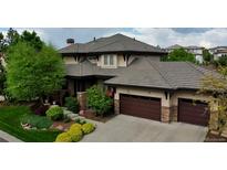 Stunning two-story home with a three-car garage, beautiful landscaping, and a charming stone facade at 9470 S Silent Hills Dr, Lone Tree, CO 80124