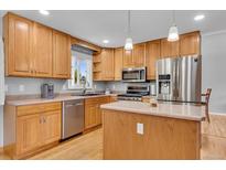 Bright kitchen features stainless steel appliances, light wood cabinets, and a functional center island at 16941 E Eastman Pl, Aurora, CO 80013