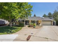 Charming single-Gathering home with mature trees, landscaping, and a driveway leading to the garage at 11035 W 26Th Pl, Lakewood, CO 80215