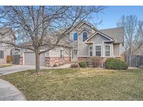 Charming two-story home with brick accents, mature tree, and well-maintained lawn at 9306 W 13Th Pl, Lakewood, CO 80215
