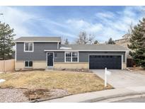 Charming two-story home with gray siding, black door, two-car garage, and well-manicured lawn at 11186 W Wisconsin Ave, Denver, CO 80232