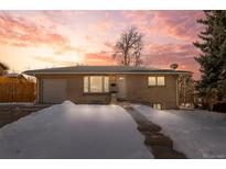 Ranch style home with attached garage and snow covered yard at 4070 W Dartmouth Ave, Denver, CO 80236