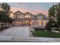 Elegant two-story home with a stone facade and well-maintained landscaping, showcasing curb appeal at 6047 Vacquero Cir, Castle Pines, CO 80108