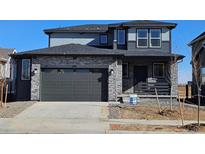 Beautiful two-story home featuring a stone facade, two-car garage, and well-manicured lawn at 490 Grey Rock St, Brighton, CO 80601