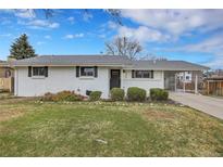 Charming, freshly painted single-story home featuring a well-maintained front yard and covered parking at 9565 W 12Th Pl, Lakewood, CO 80215